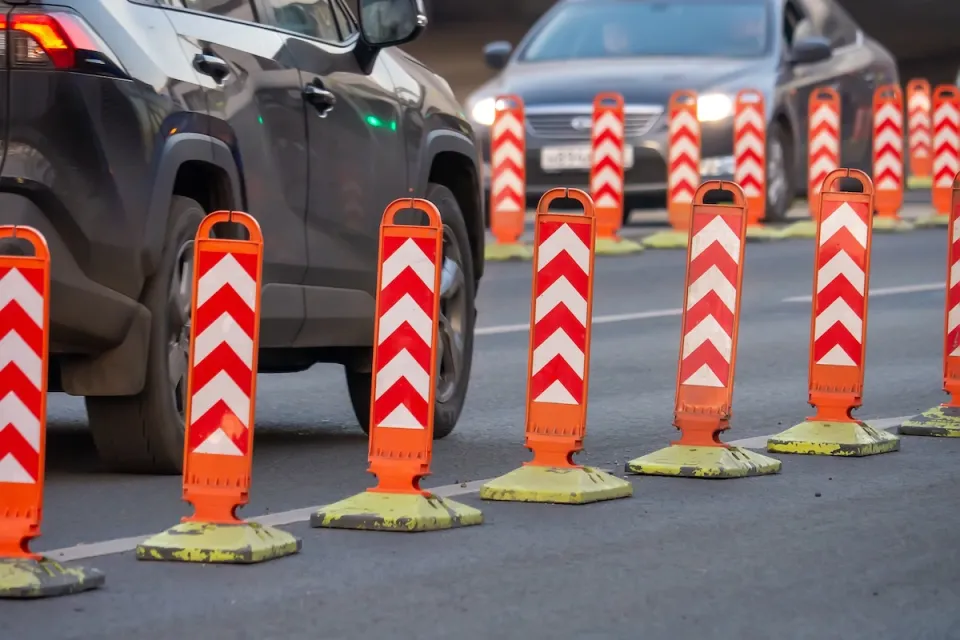 Orange and white plastic bollards delineating bike lane.